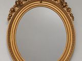 an ornate gold framed mirror hanging on a wall
