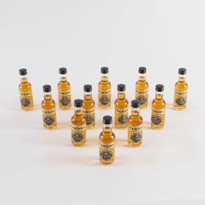 plusieurs petites bouteilles de whisky posées sur une surface blanche