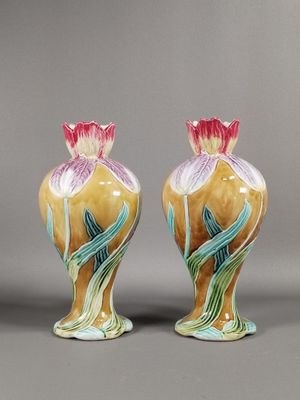 une paire de vases en céramique ornés de fleurs sur un fond gris