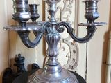 un candélabre en argent avec trois bougies posé sur une table noire