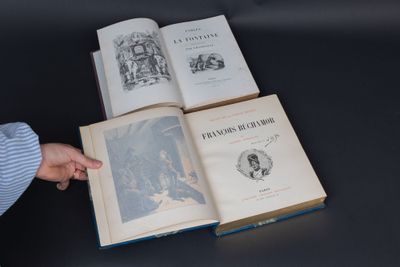 une personne montrant du doigt un livre posé sur une table