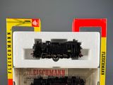 a black and red train in a box next to a red and yellow box
