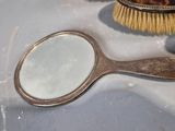 a mirror and a brush sitting on a sink