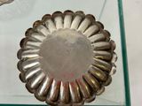 a glass table with a silver plate and a glass bowl on it