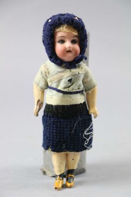 a small doll that is wearing a blue hat and dress