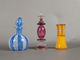 trois vases en verre de couleurs différentes posés sur une table
