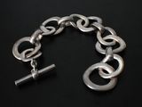 silver chain bracelet with links and a bar on a black background