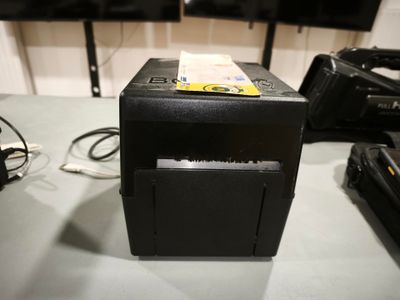 une petite imprimante posée sur une table, avec plein de câbles