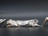 two silver figurines of a horse and a horse on a table