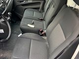 the interior of a white van with black seats and a steering wheel