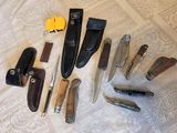 many different types of knives and knives laid out on a bed