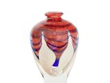 a glass vase with a red and white design on it