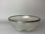 a glass bowl with a silver rim on a table