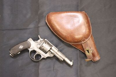 un pistolet et un étui en cuir sur fond noir