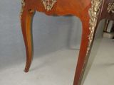 a small wooden table with a gold decoration on it