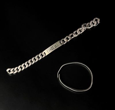 bracelet et bague en argent posés sur une surface noire avec un fond noir