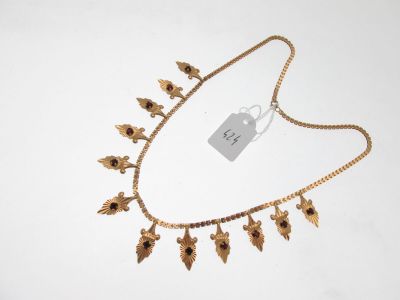 a close up of a gold necklace with flowers on it