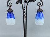 une image représentant une lampe bleue et blanche posée sur un pied en métal
