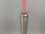 un vase en argent contenant une bougie rose
