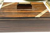 a small wooden box with a metal handle on a table