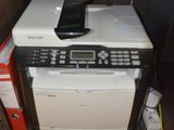 a printer and a cell phone sitting on top of a cabinet