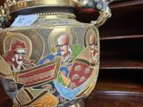 a gold and silver vase with a painting on it