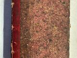 un vieux livre posé sur une table blanche, à côté d'une feuille de papier