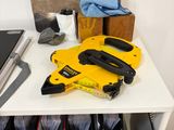 a yellow cordless nail gun on a white desk
