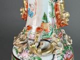 a vase with a bird on it sitting on a table
