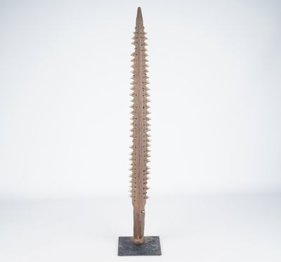une sculpture en bois représentant une grande vis posée sur un socle métallique