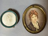 Deux portraits miniatures représentant une femme et un homme sont présentés dans un cadre doré.