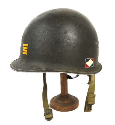casque posé sur un support en bois, sur une surface blanche, avec un fond blanc