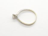 a silver ring with a diamond in it on a white surface