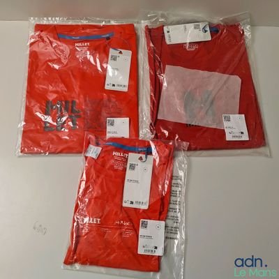 Trois t-shirts rouges sont emballés dans des sacs en plastique sur une table