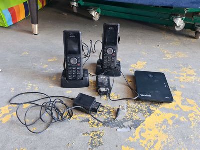 trois téléphones et un ordinateur portable posés par terre les uns à côté des autres