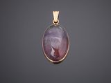 a gold pendant with a purple stone in the center