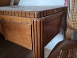a wooden desk with a wicker chair next to it