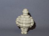 a small white figurine of a man with a hat on