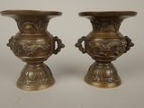two vases that are sitting on a table