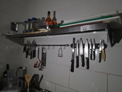de nombreux couteaux accrochés au mur au-dessus de l'évier de la cuisine