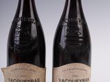 two bottles of red wine sitting next to each other on a table