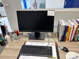 a computer monitor and keyboard on a desk in an office