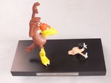 figurine représentant un oiseau et un chien, posée sur un socle noir