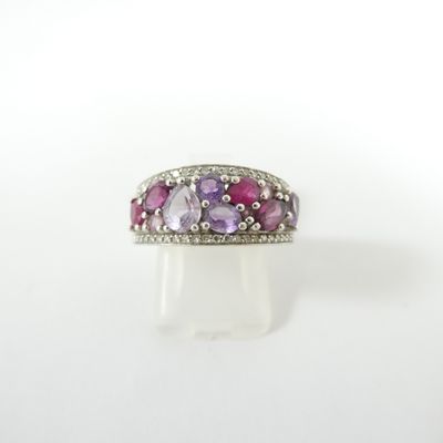 un gros plan d'une bague ornée de pierres roses et violettes