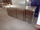 a stainless steel counter with three doors and a freezer