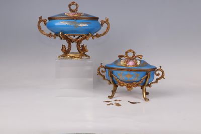 two blue and gold vases and a bowl on a stand