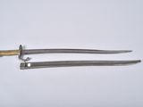 a pair of swords with a gold handle on a white surface