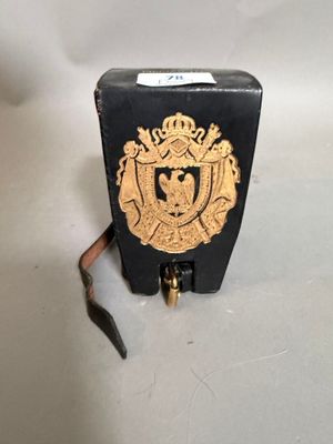 une petite boîte noire ornée d'un emblème doré