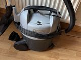 un aspirateur posé par terre à côté d'un radiateur
