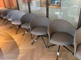 cinq chaises alignées en rang devant une baie vitrée